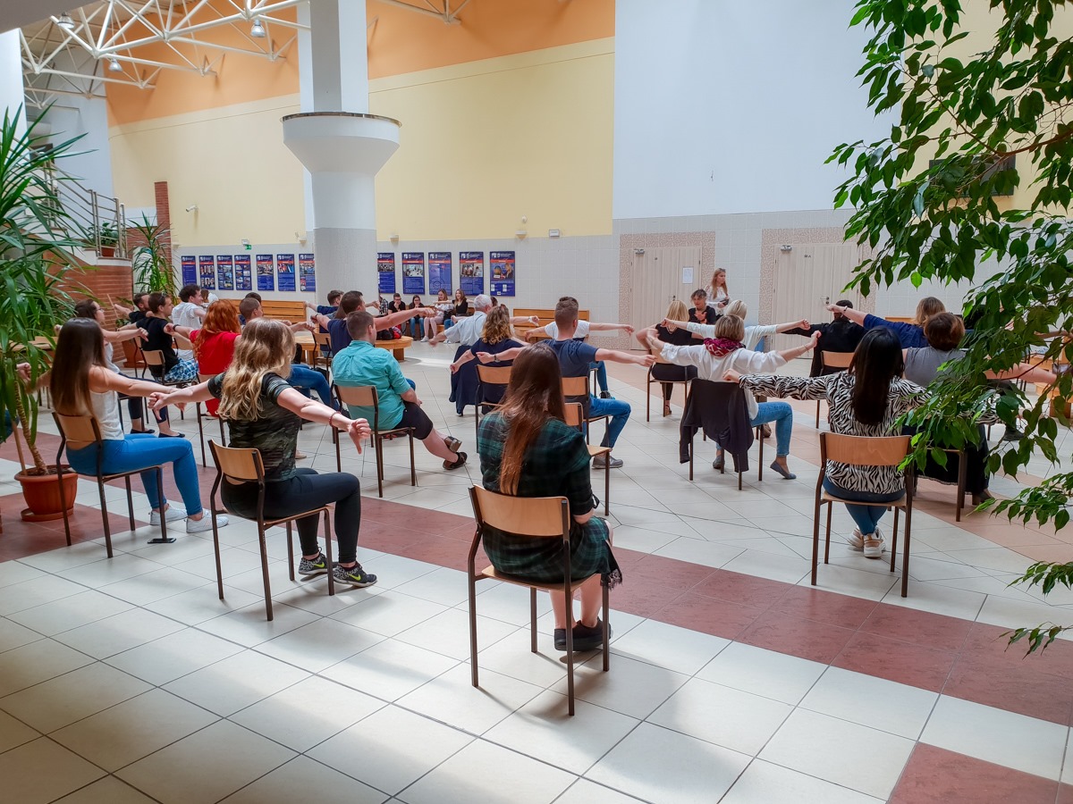 Pracownicy i studenci ćwiczący na krzesłach w Hali Berlin WIZ